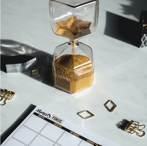 A calendar and an hourglass on a table