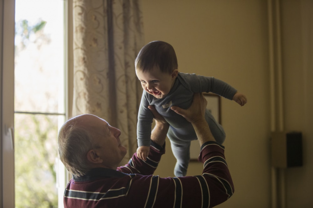 An old man playing with his grandson