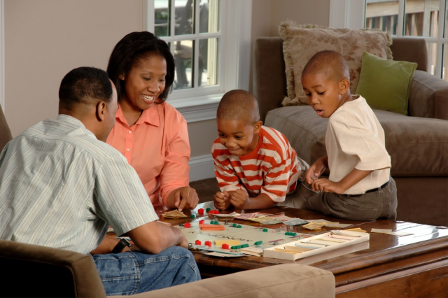 A Family of Four Playing a Game of Monopoly
